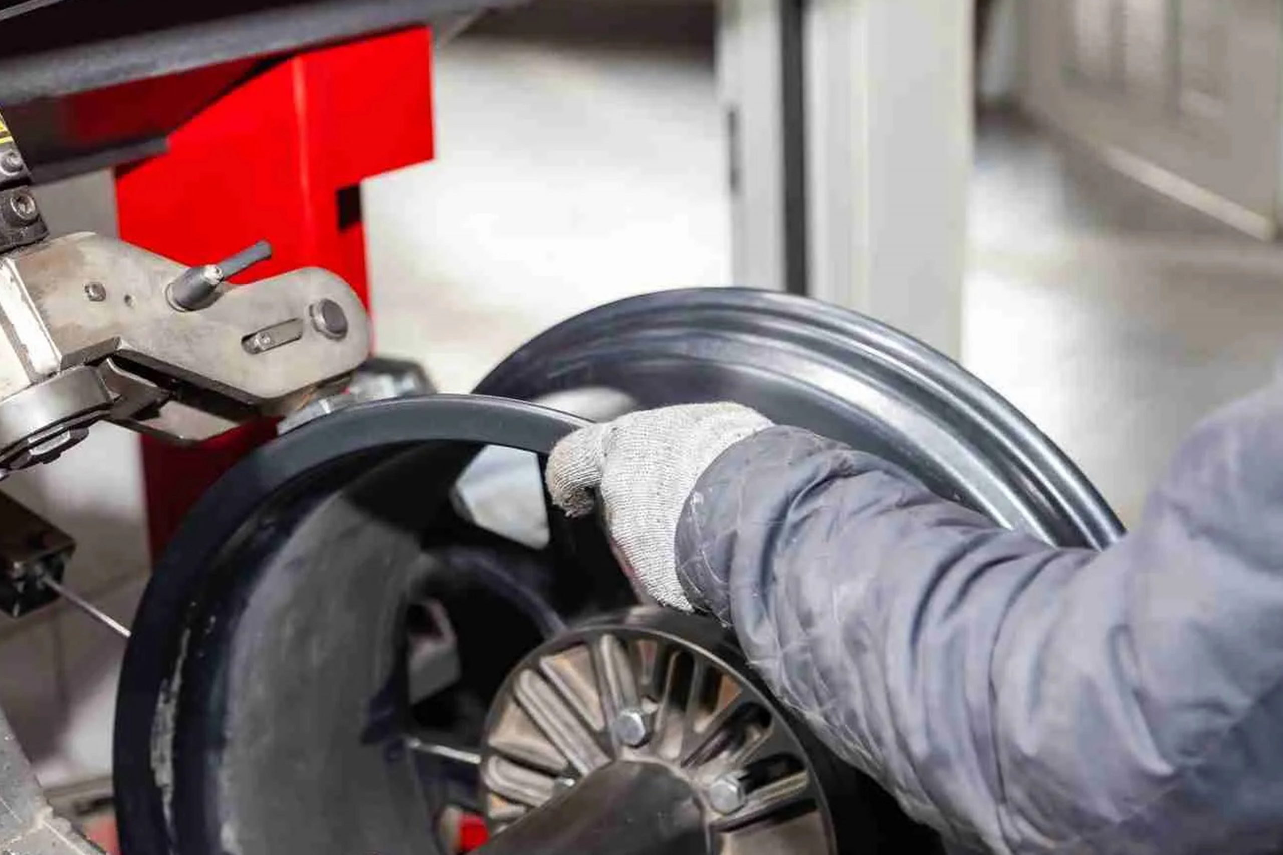 Car painter in protective clothes and mask painting automobile bumper with metallic paint and varnish in chamber workshop.